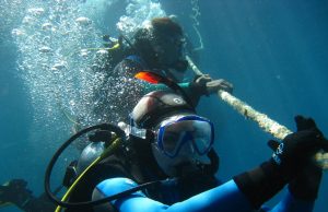 Tauchsicherheit: Zwischen Theorie und Realität Tauchsicherheit- zwei Taucher an einem seil unter Wasser im Neopren Anzug